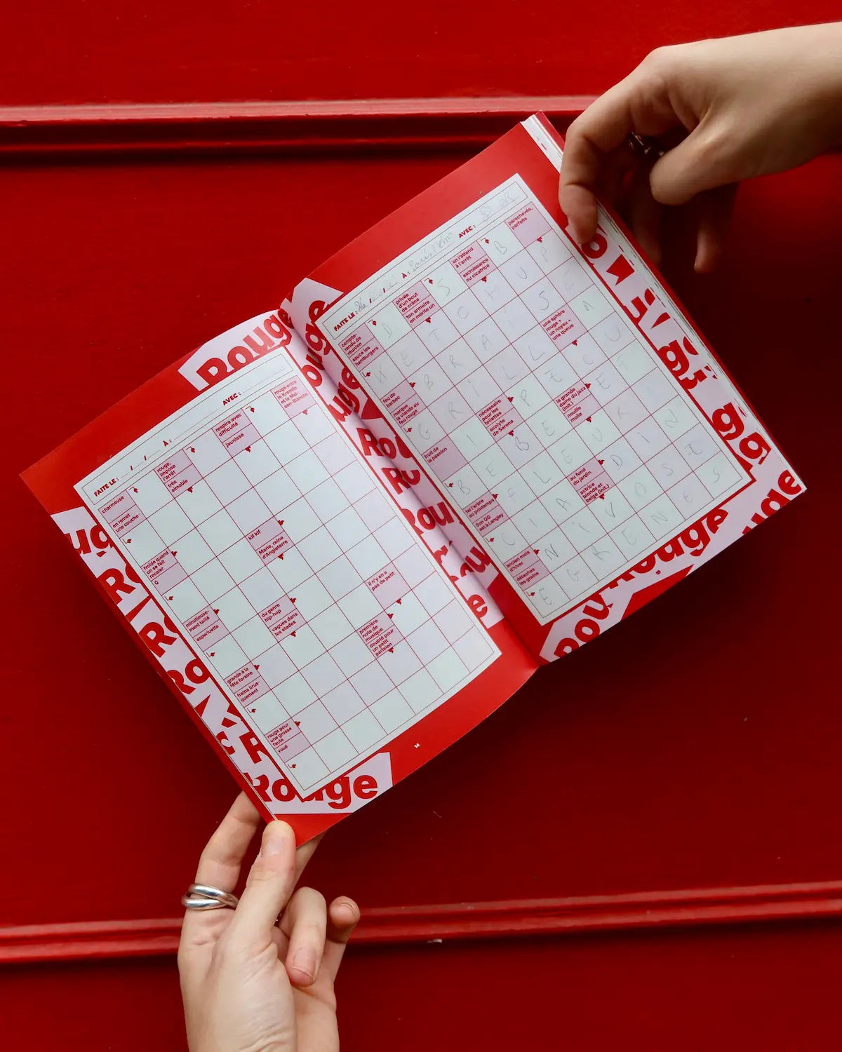 Mains tenant cahier mots fléchés Grillé DOUX ouvert