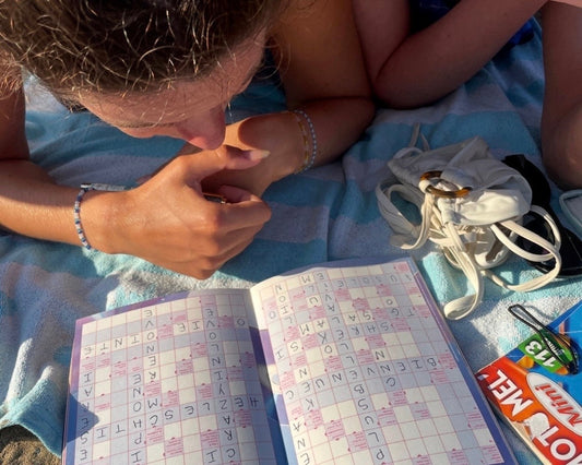 Personne jouant aux mots fléchés Grillé sur la plage, l'alternative papier à Wordle pour les fans de jeux de lettres