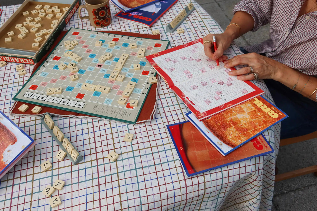 Deux joueurs complètent des grilles de mots fléchés Grillé avec des définitions modernes et inclusives
