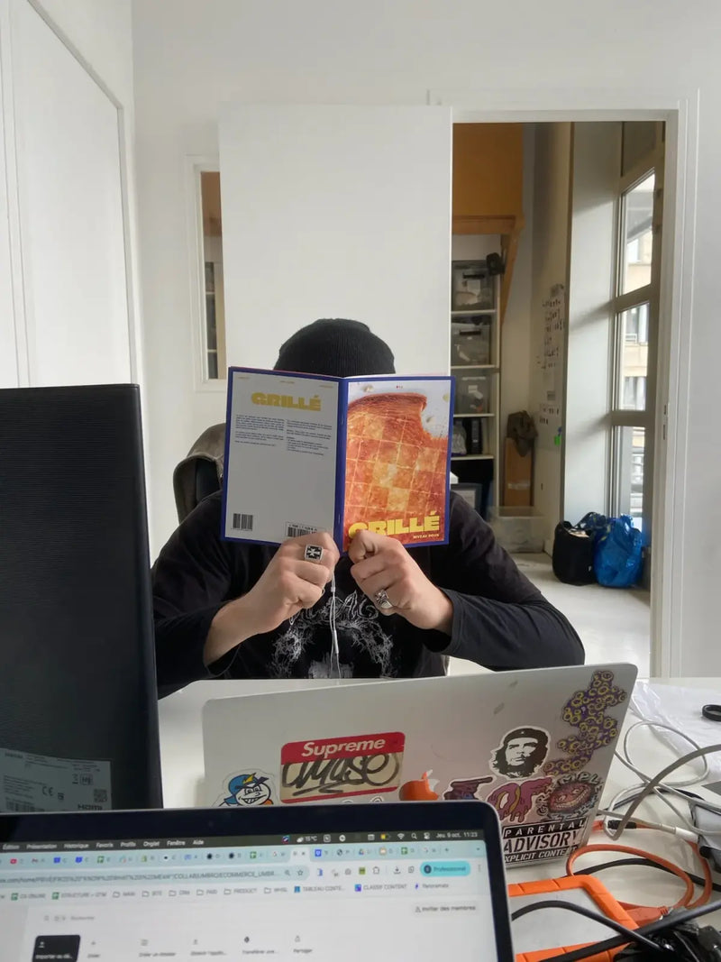 Personne lisant un cahier de mots fléchés GRILLÉ niveau Doux pendant une pause au bureau